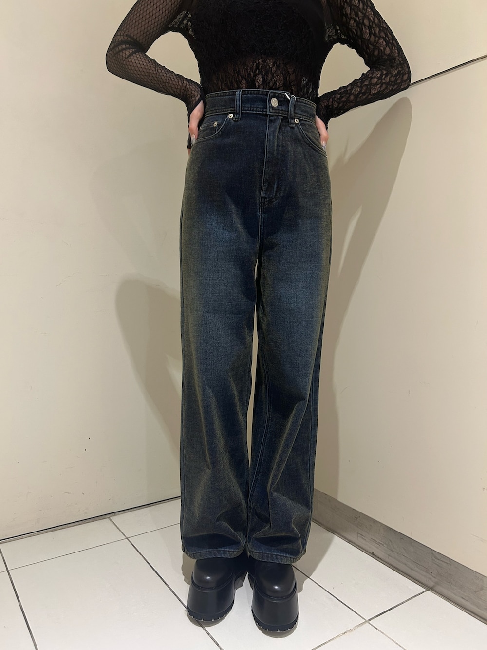 グリーン系のデニムパンツ、ブラック系のTシャツ/カットソー、ブラック系のブーツを着用したレディースの秋コーディネートの6枚目の写真