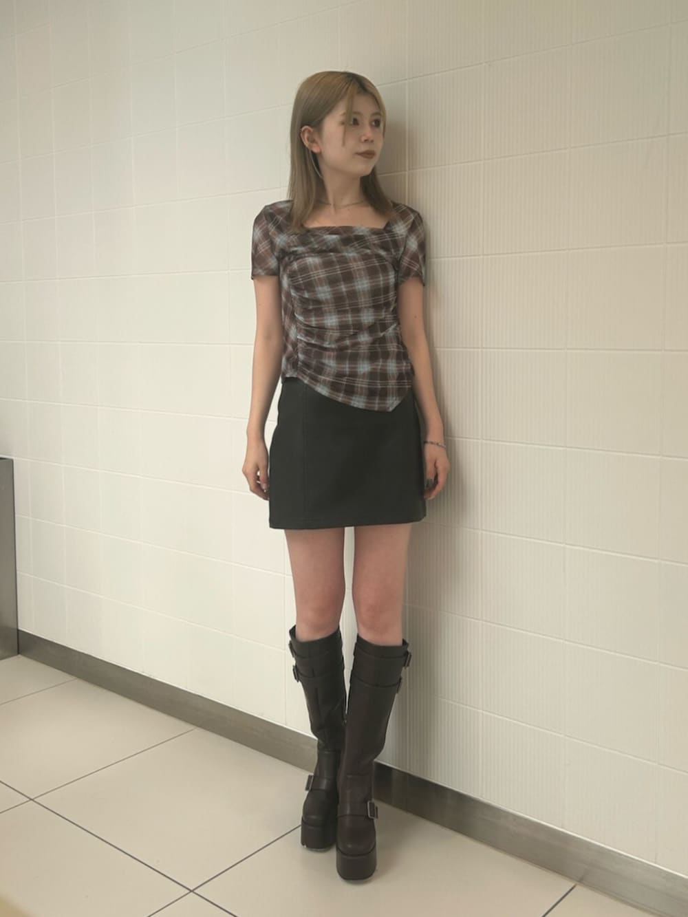 ブラック系のスカート、ブラウン系のTシャツ/カットソー、ブラック系のバックパック/リュックを着用したレディースの夏コーディネートの2枚目の写真