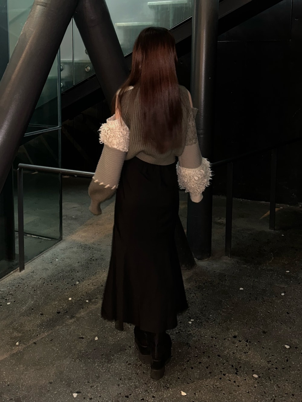 ブラウン系のニット/セーター、ブラック系のスカート、ブラック系のブーツを着用したレディースの冬コーディネートの2枚目の写真