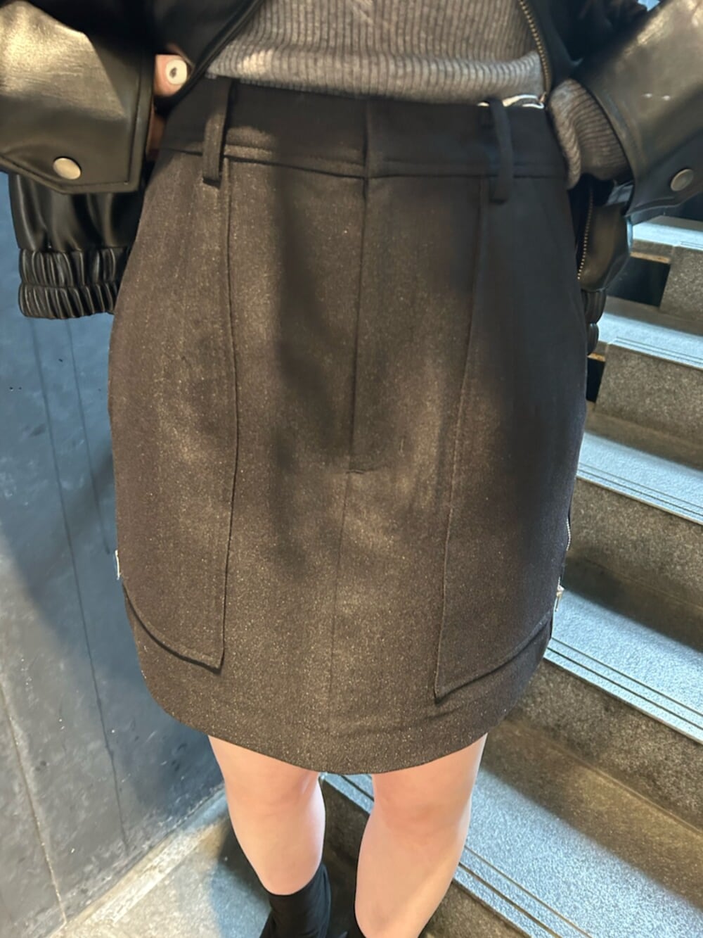 ブラック系のブーツ、ブラック系のブルゾン、ブラック系のスカートを着用したレディースの春コーディネートの7枚目の写真