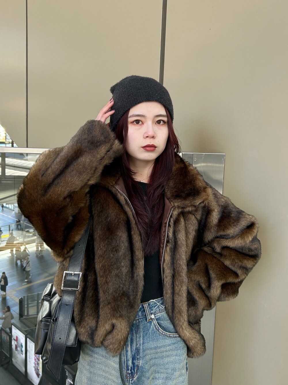 ブルー系のデニムパンツ、ブラウン系のブルゾン、ブラック系のニット/セーターを着用したレディースの冬コーディネートの4枚目の写真