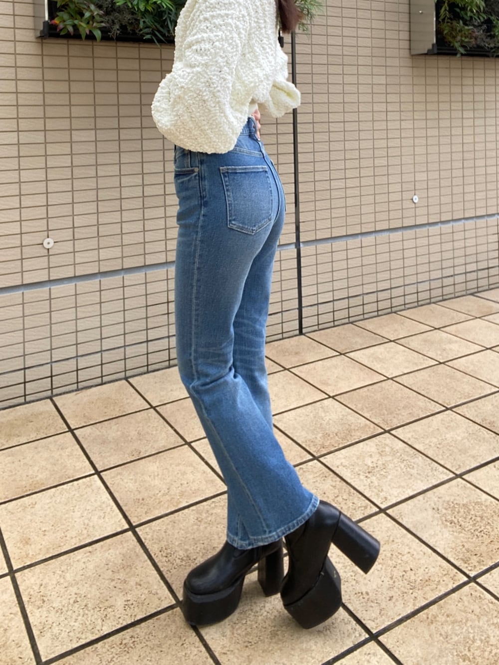 ブルー系のデニムパンツ、ホワイト系のニット/セーターを着用したレディースの秋コーディネートの7枚目の写真