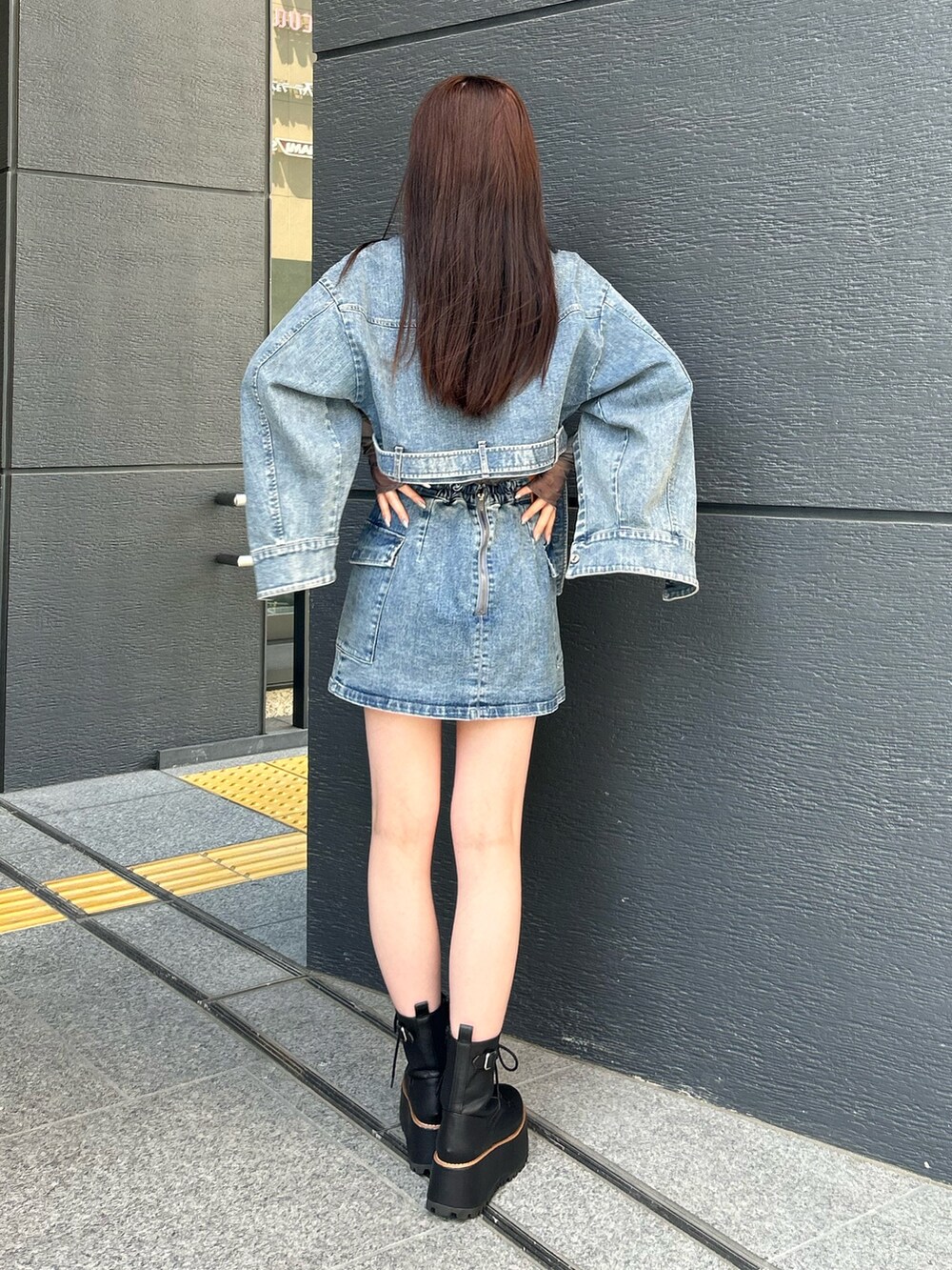 ブルー系のスカート、ブルー系のデニムジャケット、ブラック系のTシャツ/カットソーを着用したレディースの夏コーディネートの3枚目の写真