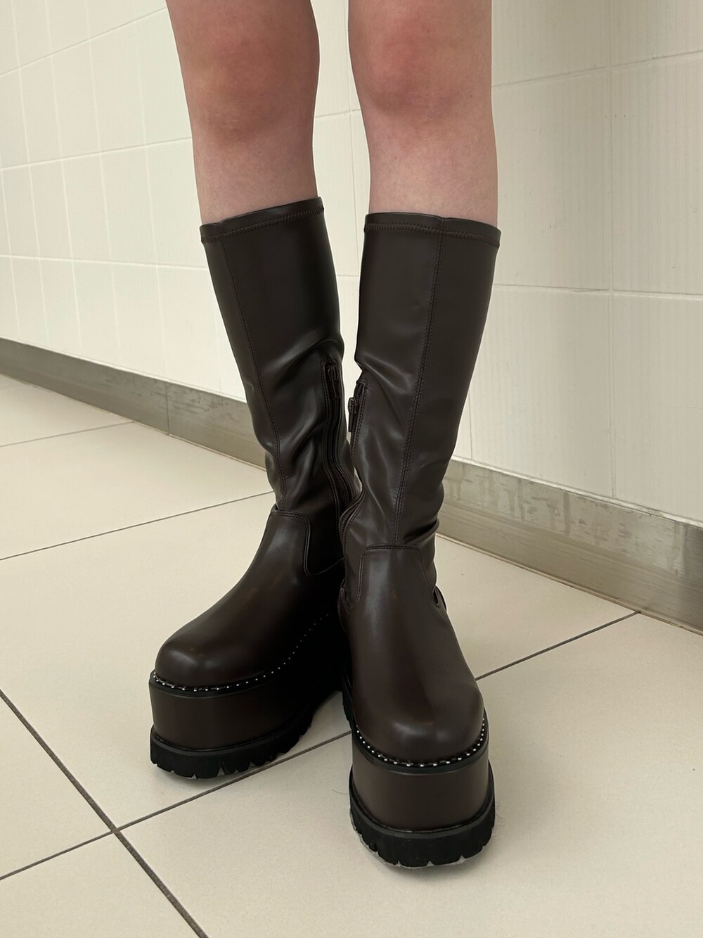 ホワイト系のスカート、ブラック系のニット/セーター、ホワイト系のムートンコートを着用したレディースの秋コーディネートの7枚目の写真