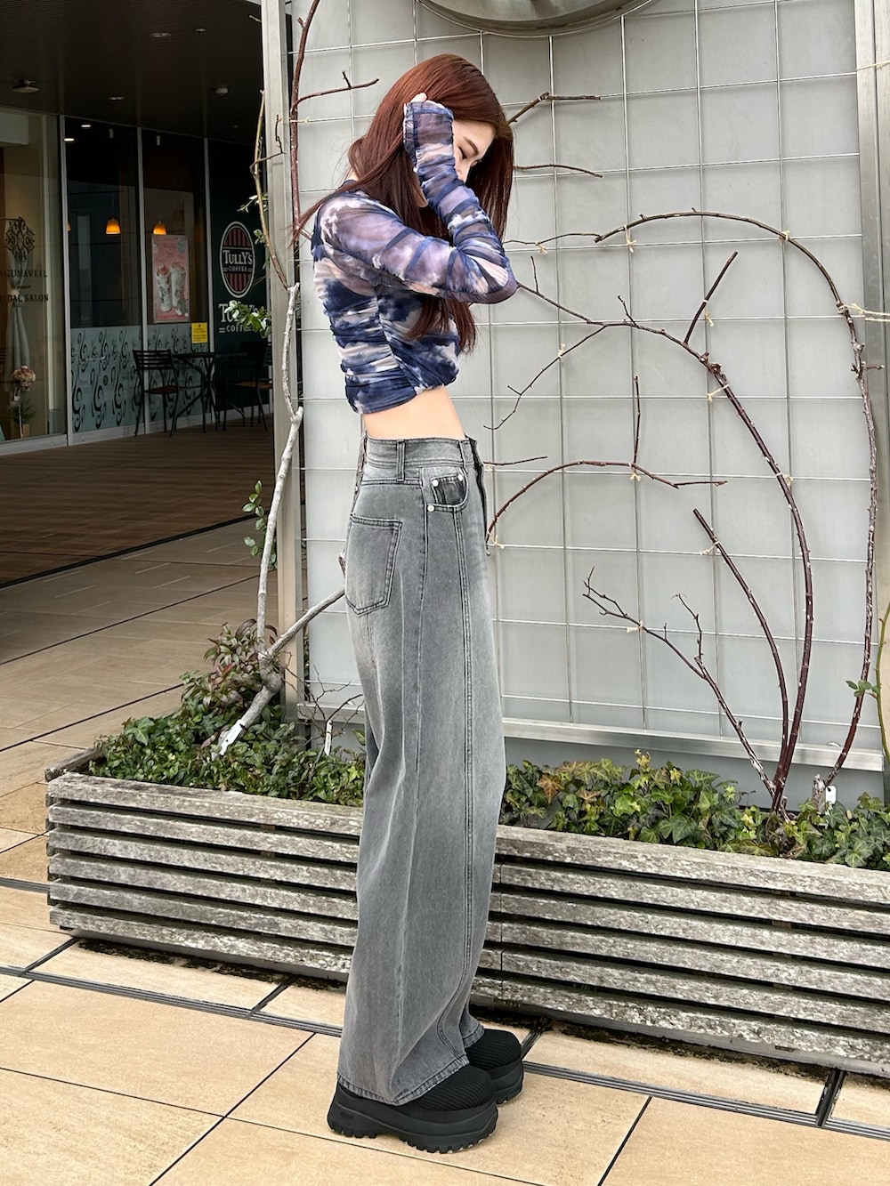 ブラック系のデニムパンツ、ブルー系のTシャツ/カットソー、ブラック系のブーツを着用したレディースの春コーディネートの3枚目の写真