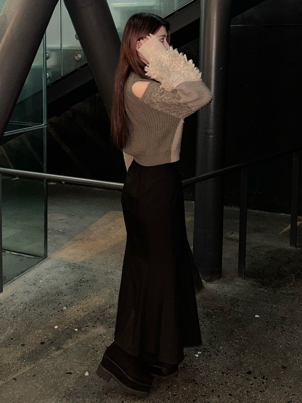 ブラウン系のニット/セーター、ブラック系のスカート、ブラック系のブーツを着用したレディースの冬コーディネートの3枚目の写真