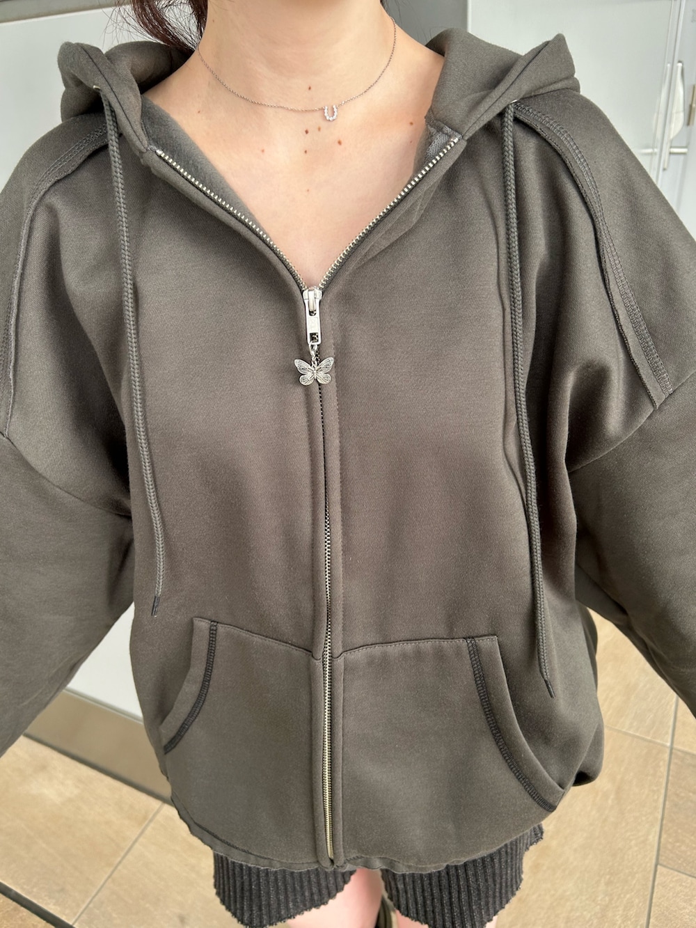 グレー系のパーカー、ブラック系のその他パンツ、ブラック系のブーツを着用したレディースの秋コーディネートの6枚目の写真