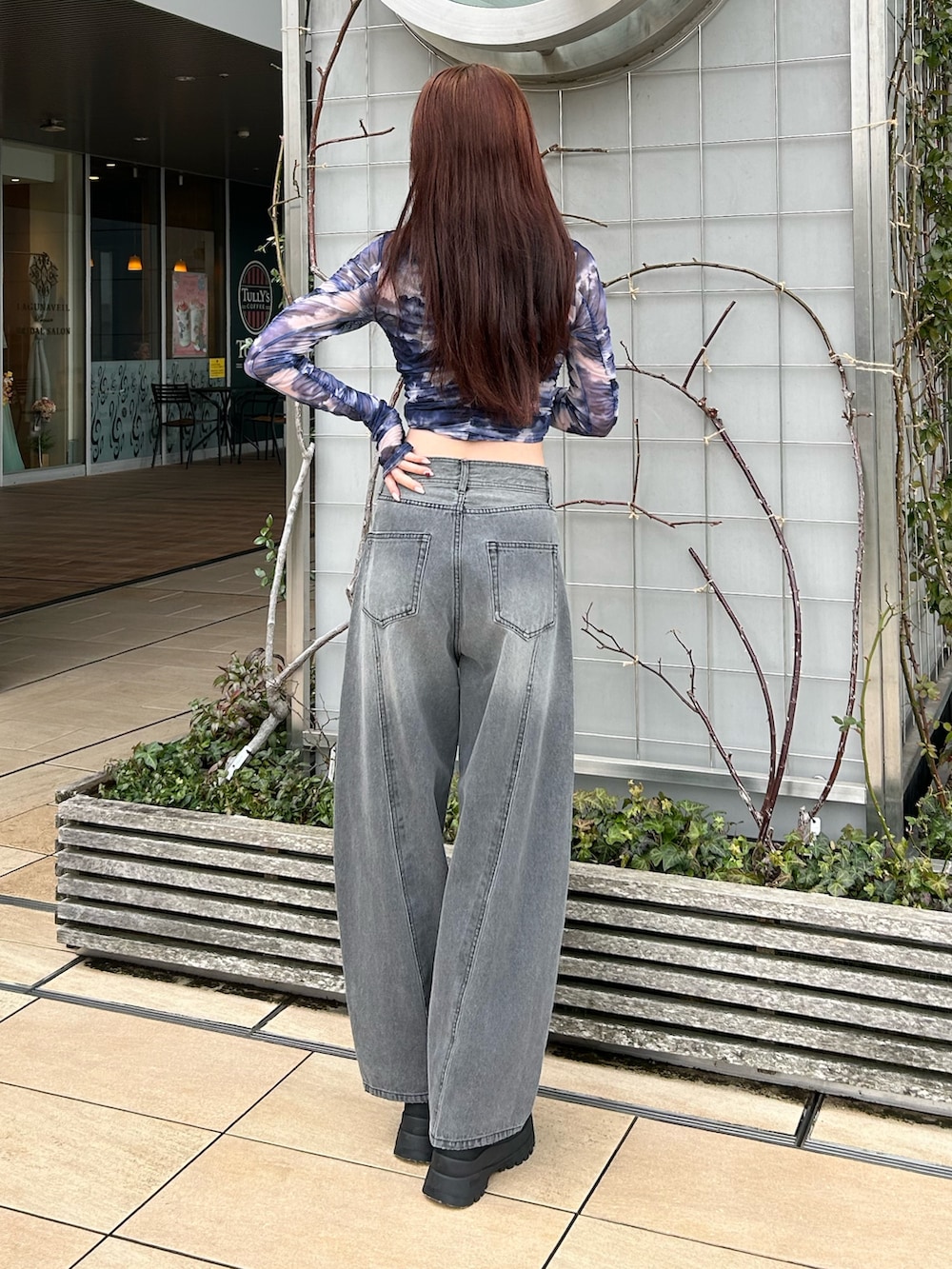 ブラック系のデニムパンツ、ブルー系のTシャツ/カットソー、ブラック系のブーツを着用したレディースの春コーディネートの2枚目の写真