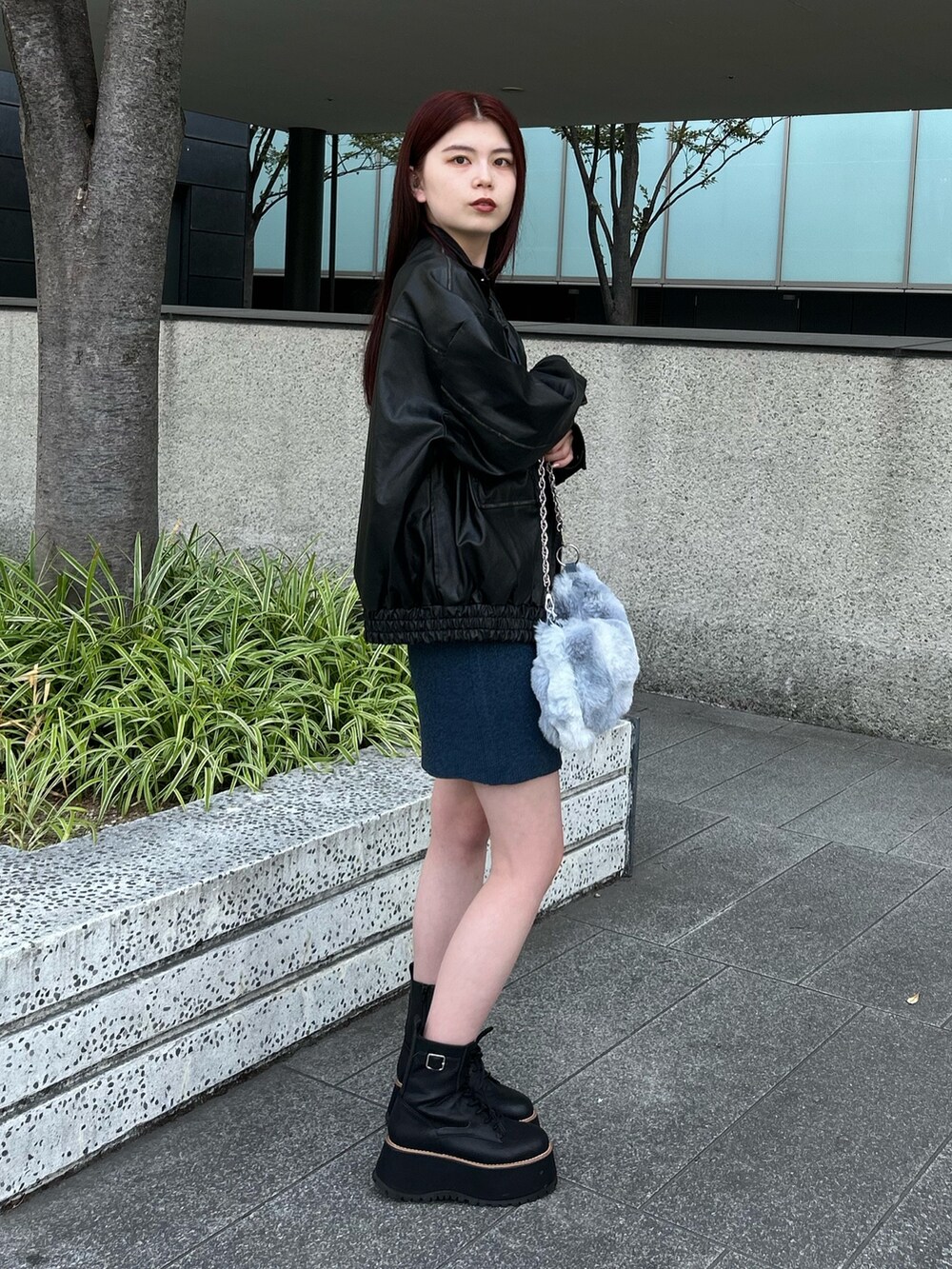 ブルー系のワンピース、ブラック系のライダースジャケット、ブラック系のブーツを着用したレディースの秋コーディネートの2枚目の写真