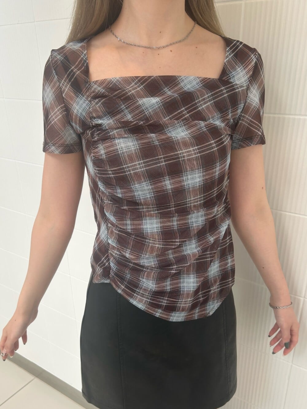 ブラック系のスカート、ブラウン系のTシャツ/カットソー、ブラック系のバックパック/リュックを着用したレディースの夏コーディネートの5枚目の写真