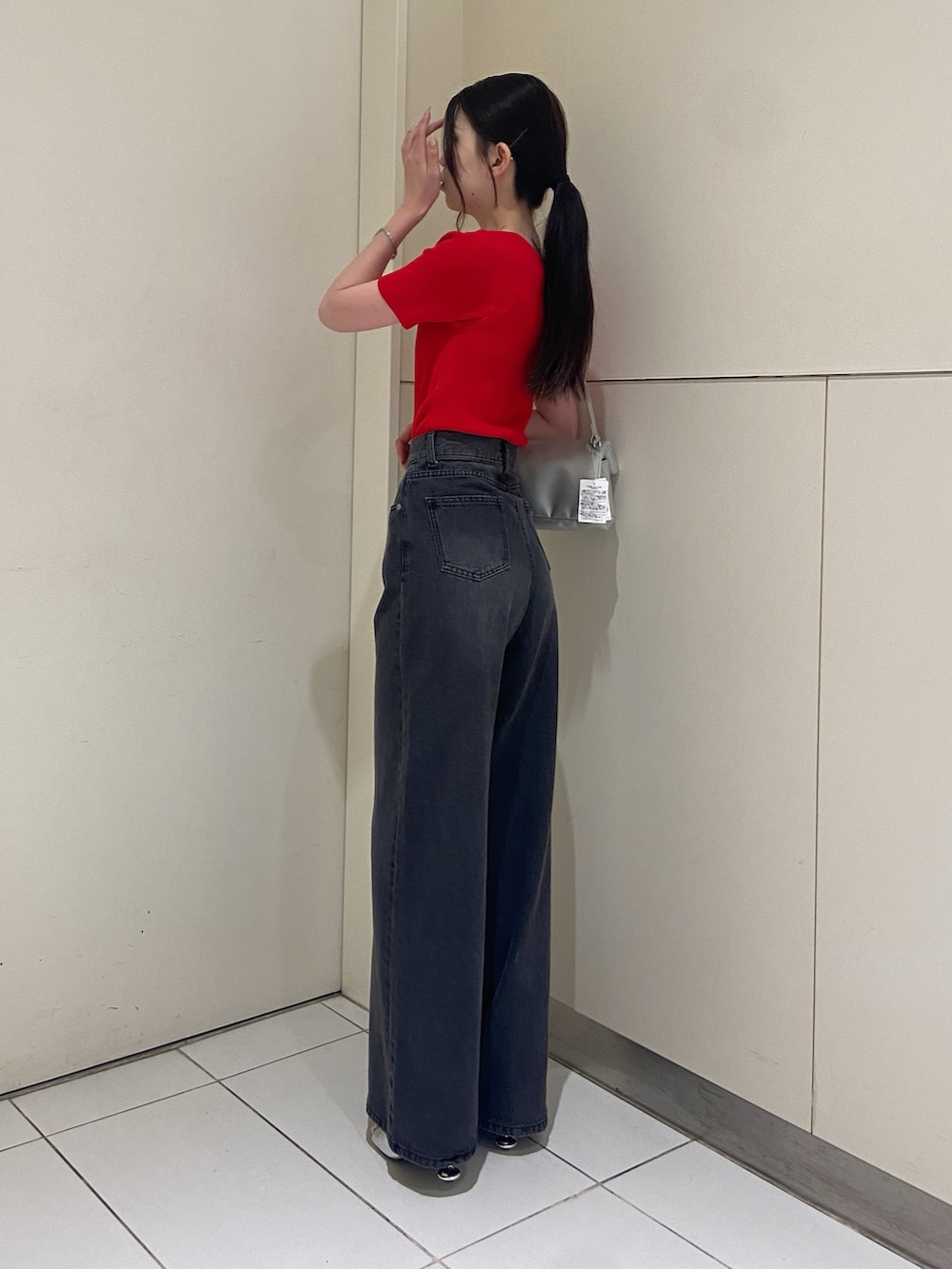 ブラック系のデニムパンツ、レッド系のニット/セーターを着用したレディースの夏コーディネートの3枚目の写真