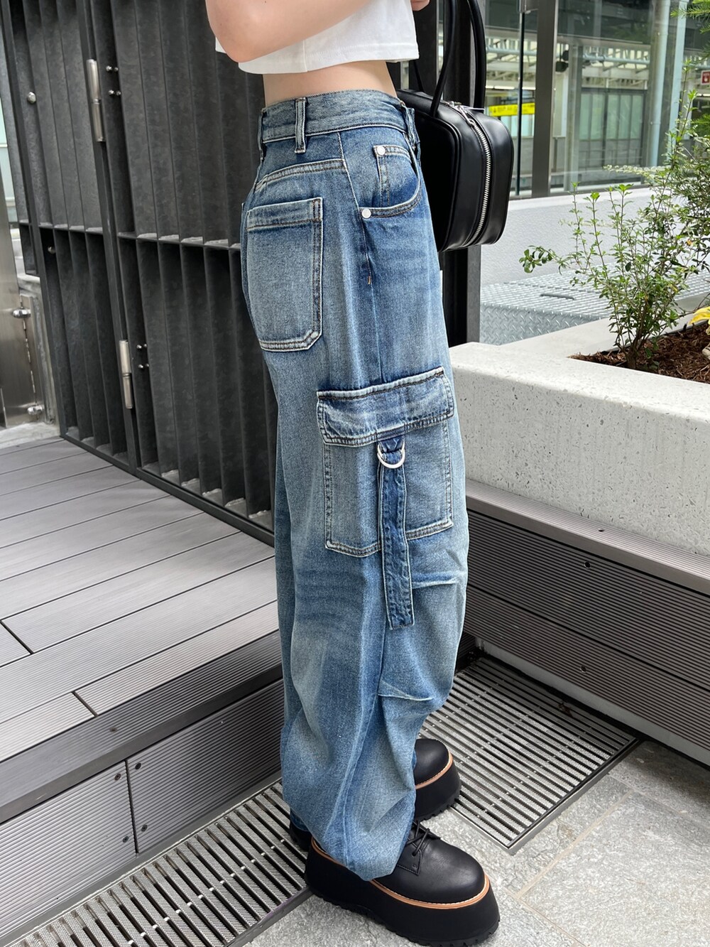 ブルー系のデニムパンツ、ホワイト系のTシャツ/カットソー、ブラック系のボストンバッグを着用したレディースの夏コーディネートの7枚目の写真