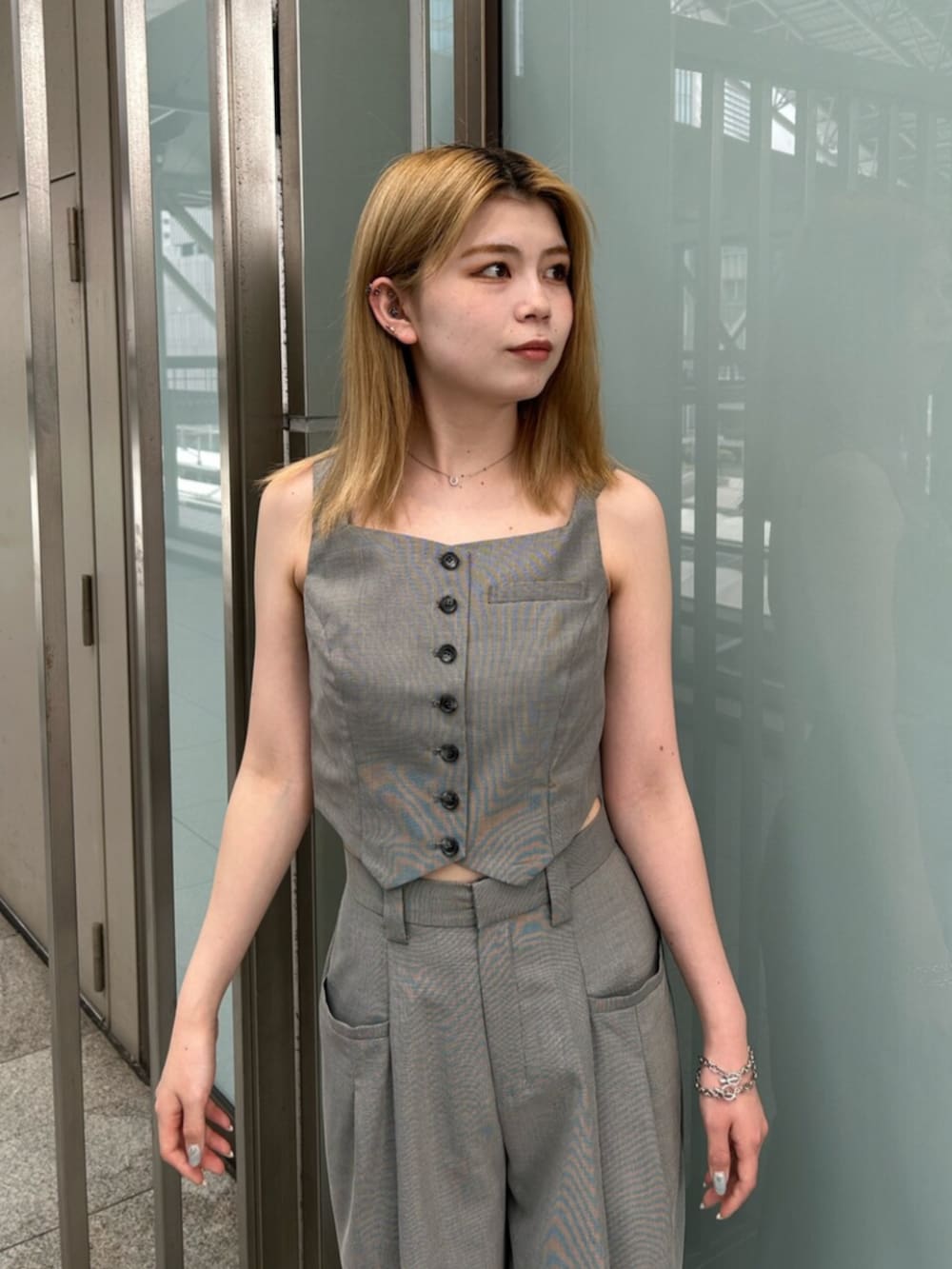 ブラック系のブーツ、グレー系のスラックス、グレー系のベストを着用したレディースの夏コーディネートの4枚目の写真