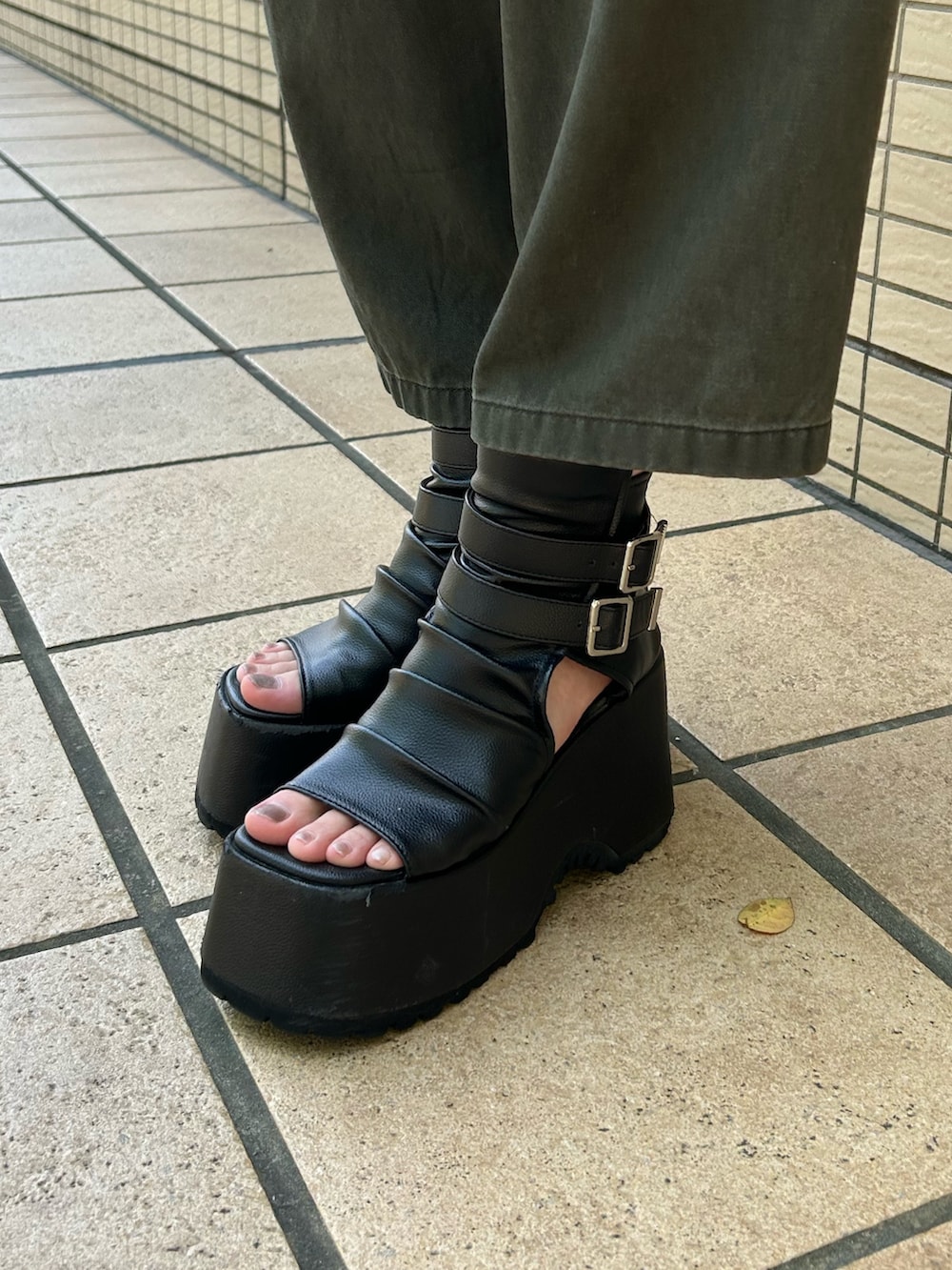 ブラック系のニット/セーター、グリーン系のその他パンツ、ブラック系のブーツを着用したレディースの夏コーディネートの7枚目の写真