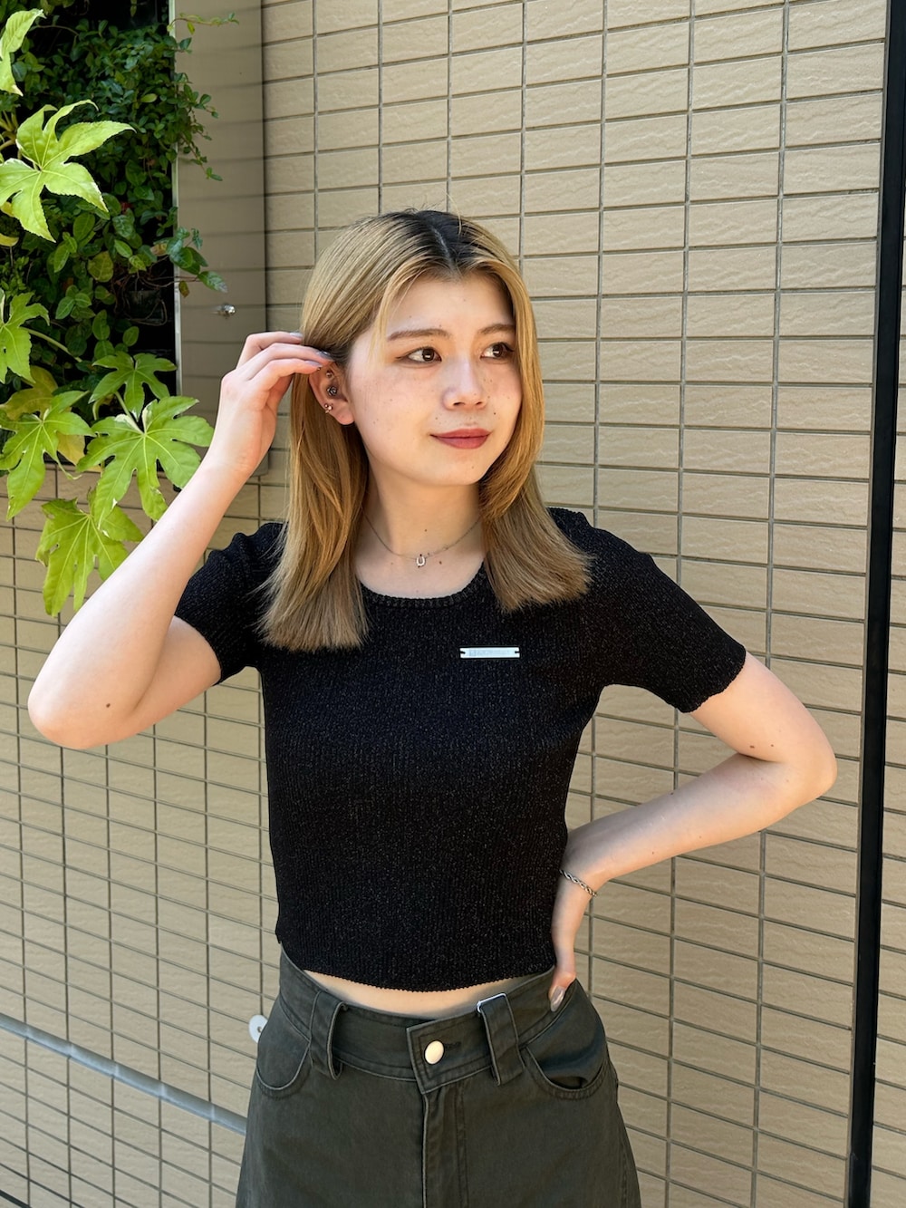 ブラック系のニット/セーター、グリーン系のその他パンツ、ブラック系のブーツを着用したレディースの夏コーディネートの4枚目の写真