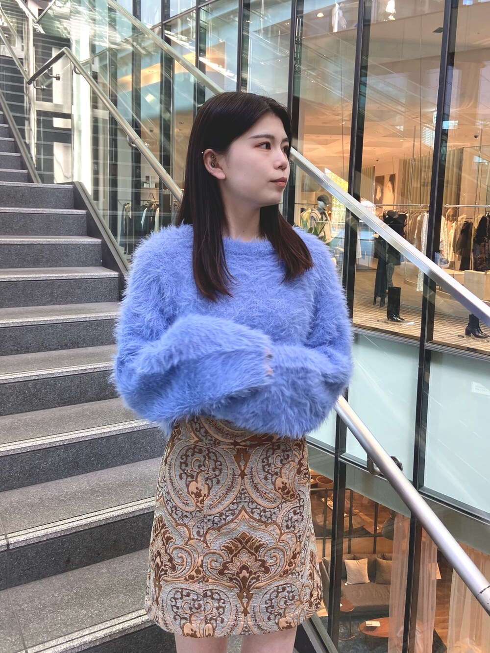 ブルー系のスカート、ブルー系のニット/セーター、ホワイト系のブーツを着用したレディースの秋コーディネートの4枚目の写真