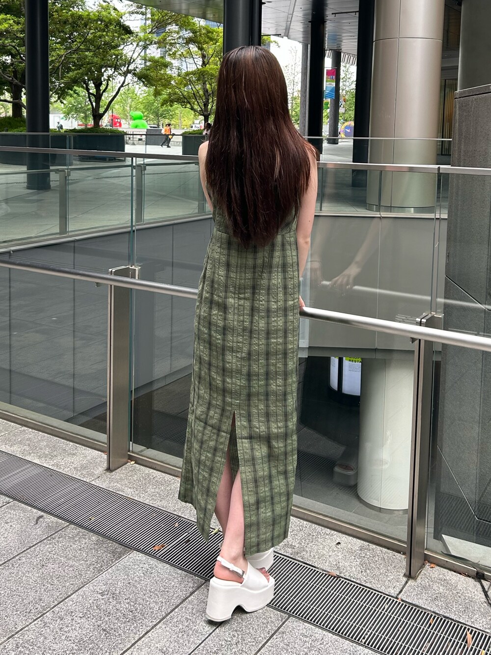 グリーン系のワンピースを着用したレディースの夏コーディネートの2枚目の写真