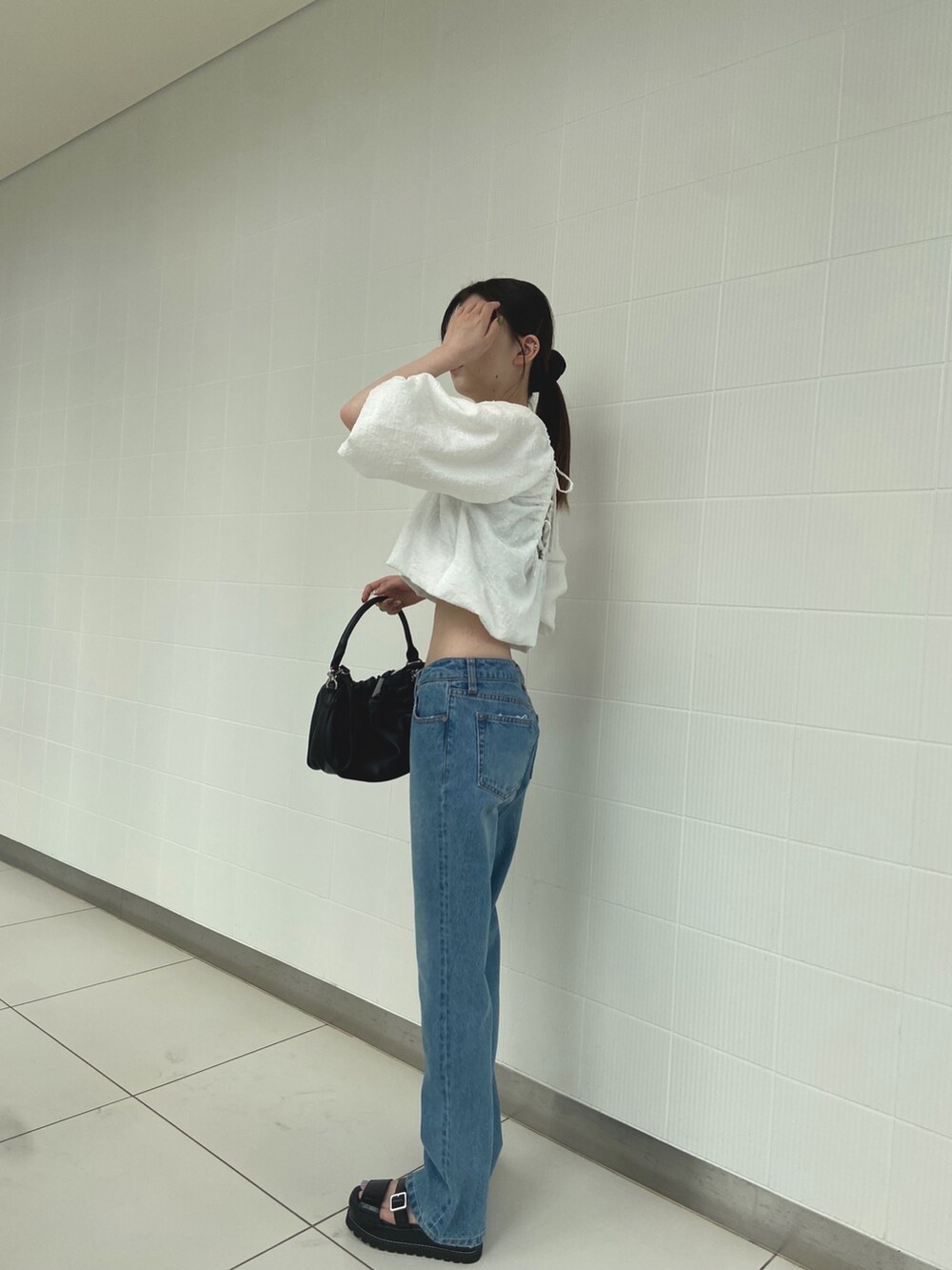 ホワイト系のシャツ/ブラウス、ブルー系のデニムパンツ、ブラック系のサンダルを着用したレディースの夏コーディネートの3枚目の写真