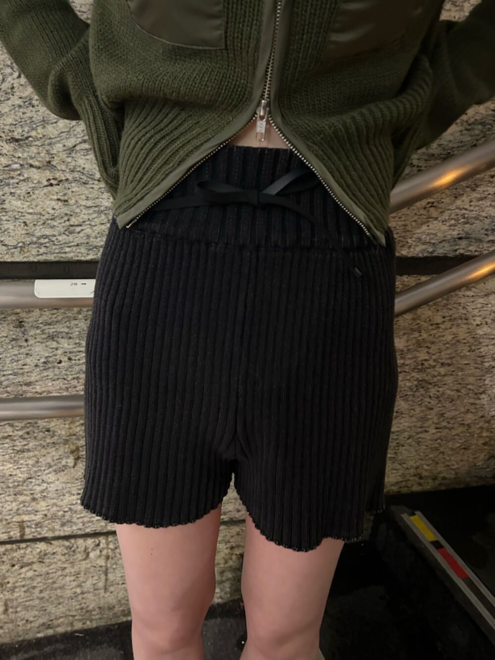 ブラック系のブーツ、グリーン系のニット/セーター、ブラック系のその他パンツを着用したレディースの冬コーディネートの6枚目の写真