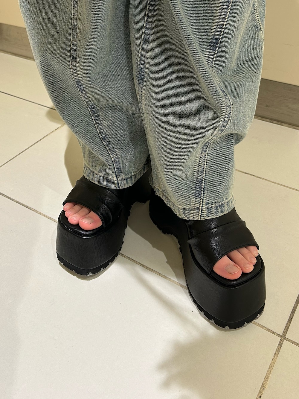 ブルー系のデニムパンツ、ブラック系のブーツ、グレー系のキャミソールを着用したレディースの春コーディネートの5枚目の写真