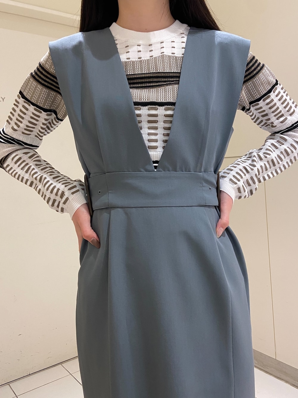 ブルー系のワンピース、ホワイト系のニット/セーター、ブラック系のブーツを着用したレディースの冬コーディネートの4枚目の写真