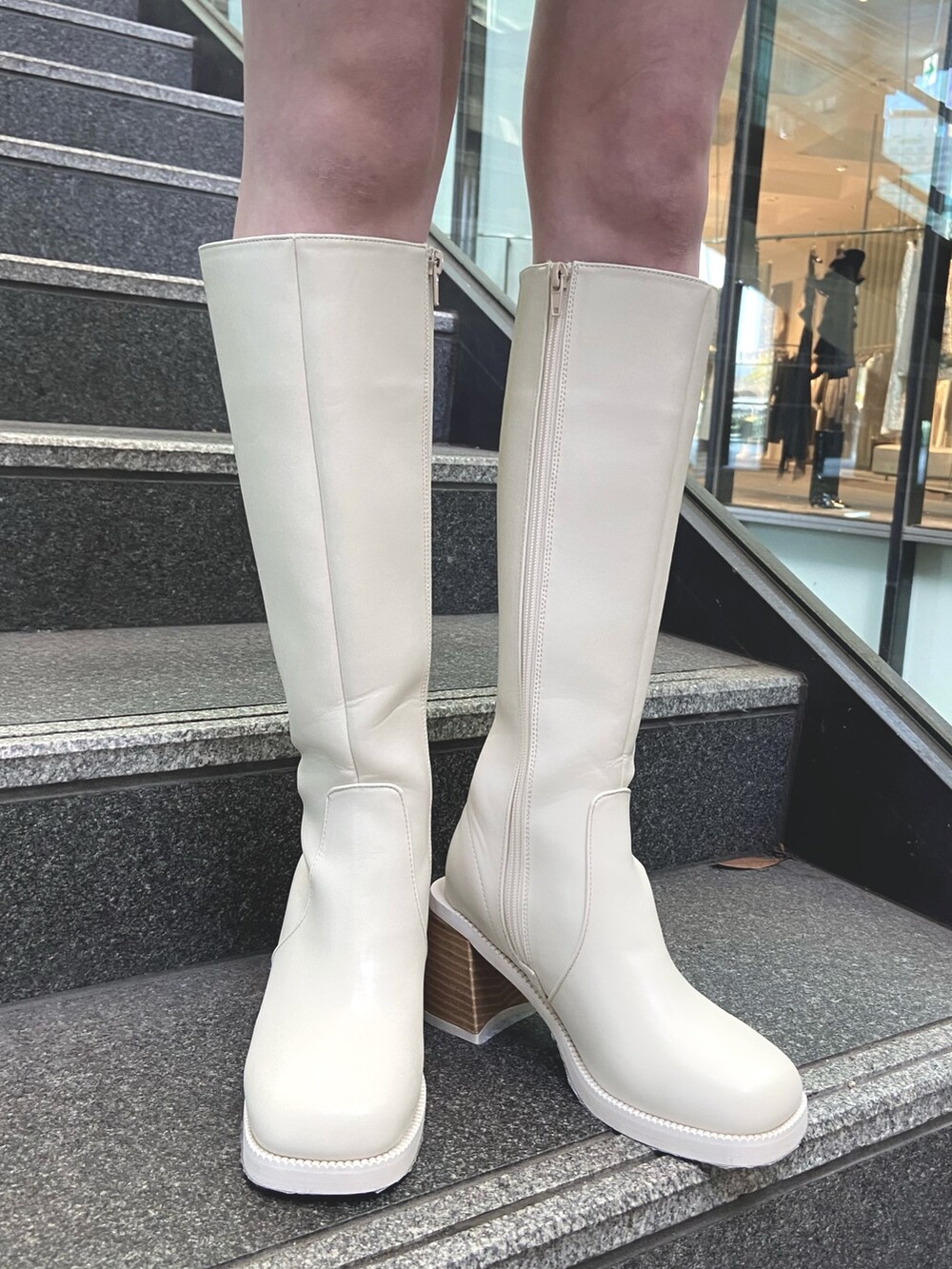 ブルー系のスカート、ブルー系のニット/セーター、ホワイト系のブーツを着用したレディースの秋コーディネートの8枚目の写真