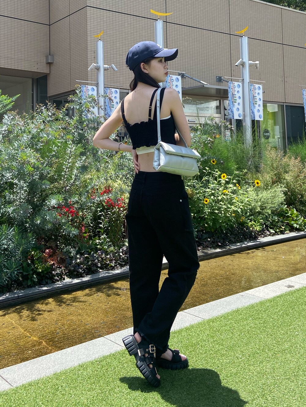 ブラック系のデニムパンツ、ブラック系のシャツ/ブラウス、ブルー系のキャップを着用したレディースの夏コーディネートの2枚目の写真