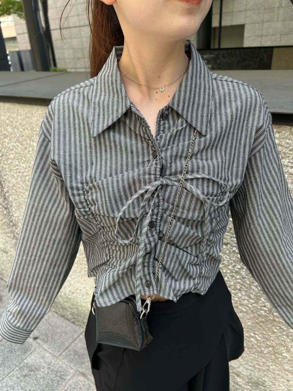 グレー系のシャツ/ブラウス、ブラック系のスカート、ブラック系のブーツを着用したレディースの夏コーディネートの5枚目の写真