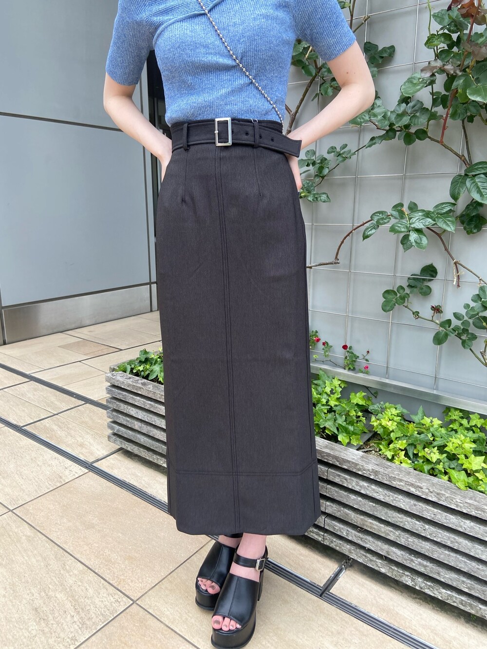 ブラック系のスカート、ブルー系のニット/セーターを着用したレディースの春コーディネートの6枚目の写真