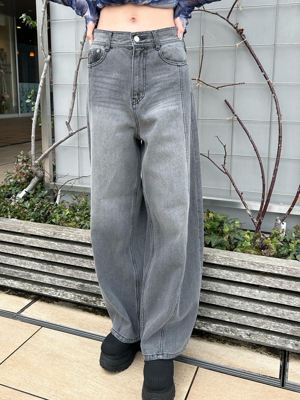 ブラック系のデニムパンツ、ブルー系のTシャツ/カットソー、ブラック系のブーツを着用したレディースの春コーディネートの5枚目の写真