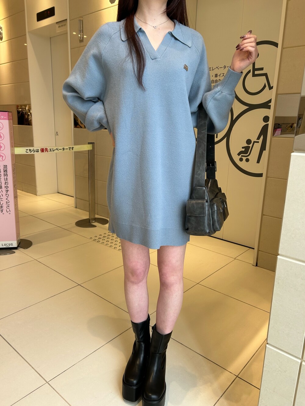 ブルー系のワンピース、ブラック系のブーツを着用したレディースの冬コーディネートの4枚目の写真