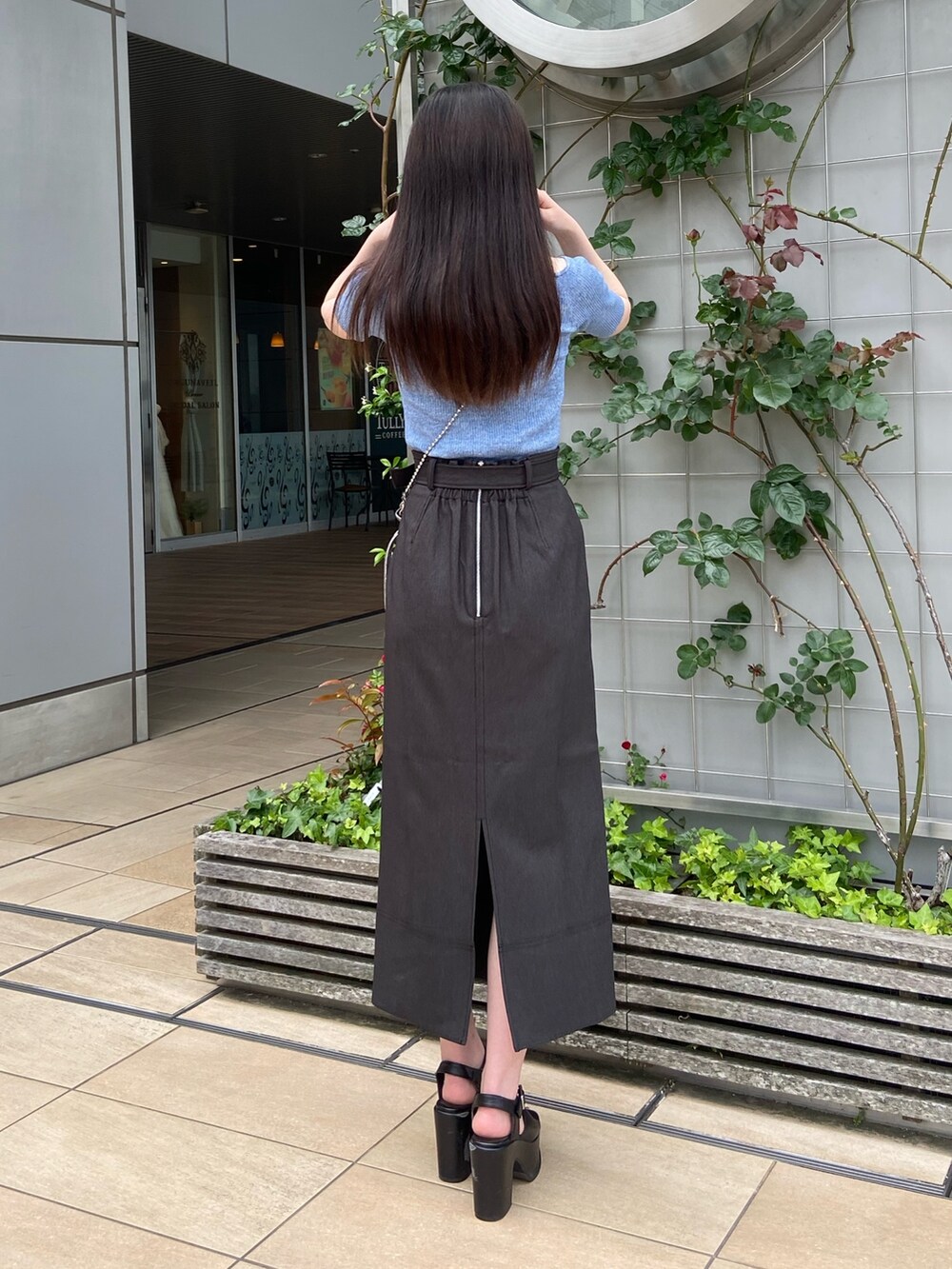 ブラック系のスカート、ブルー系のニット/セーターを着用したレディースの春コーディネートの3枚目の写真