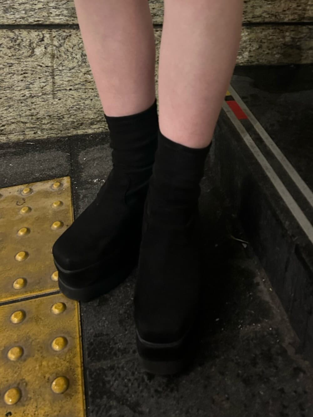 ブラック系のブーツ、グリーン系のニット/セーター、ブラック系のその他パンツを着用したレディースの冬コーディネートの7枚目の写真