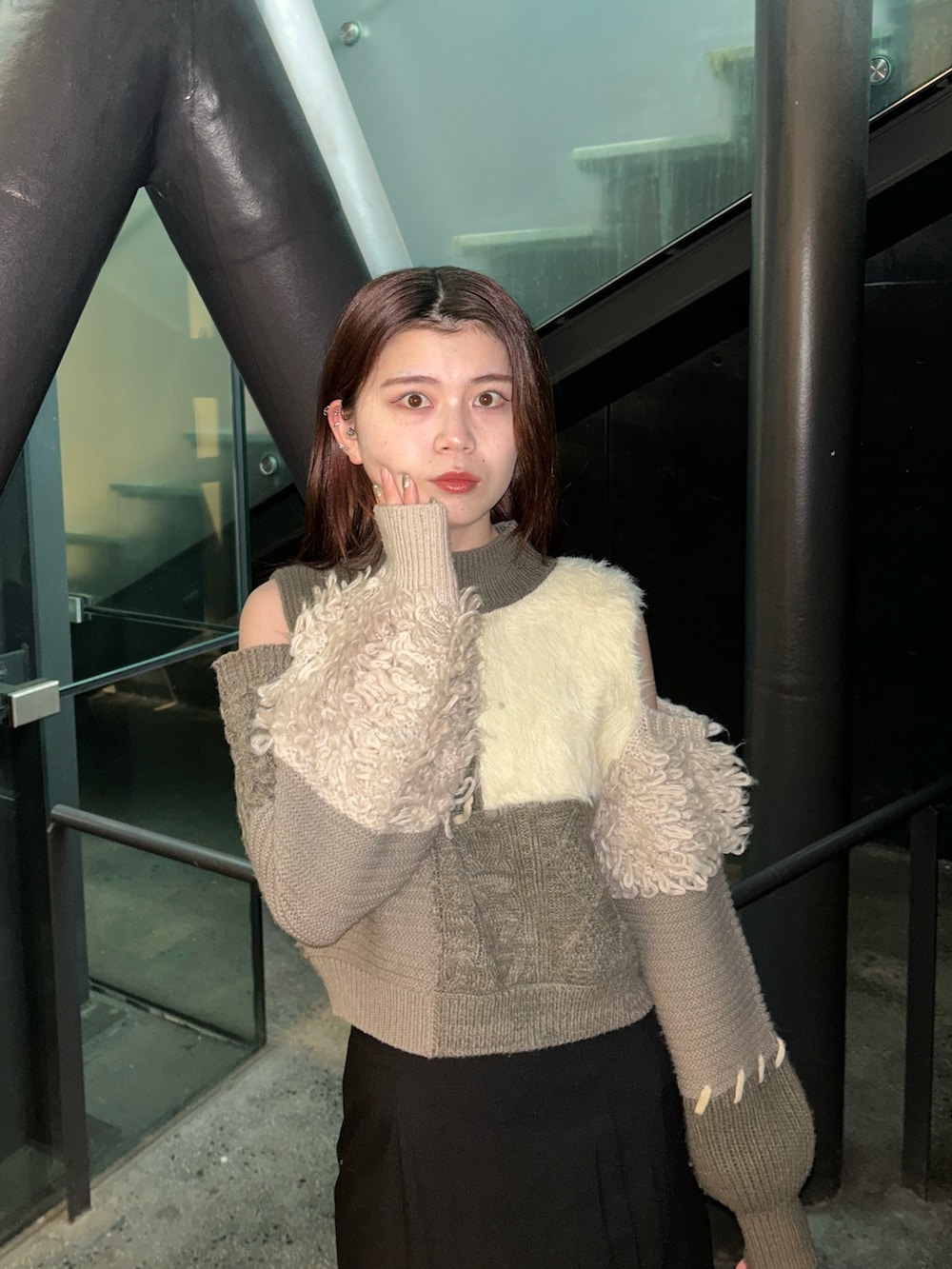 ブラウン系のニット/セーター、ブラック系のスカート、ブラック系のブーツを着用したレディースの冬コーディネートの4枚目の写真