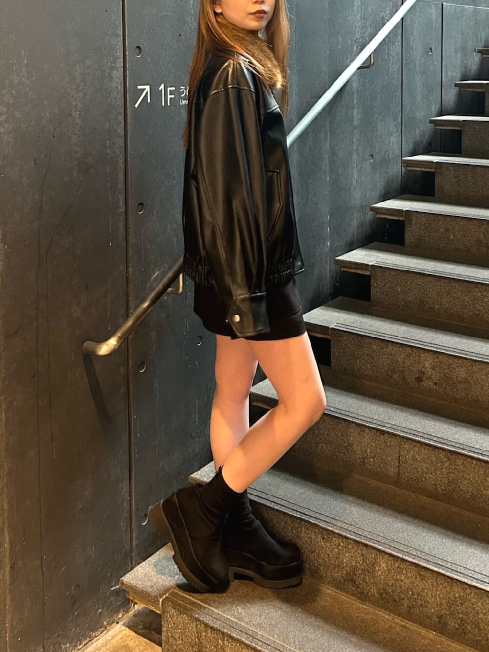 ブラック系のブーツ、ブラック系のブルゾン、ブラック系のスカートを着用したレディースの春コーディネートの4枚目の写真