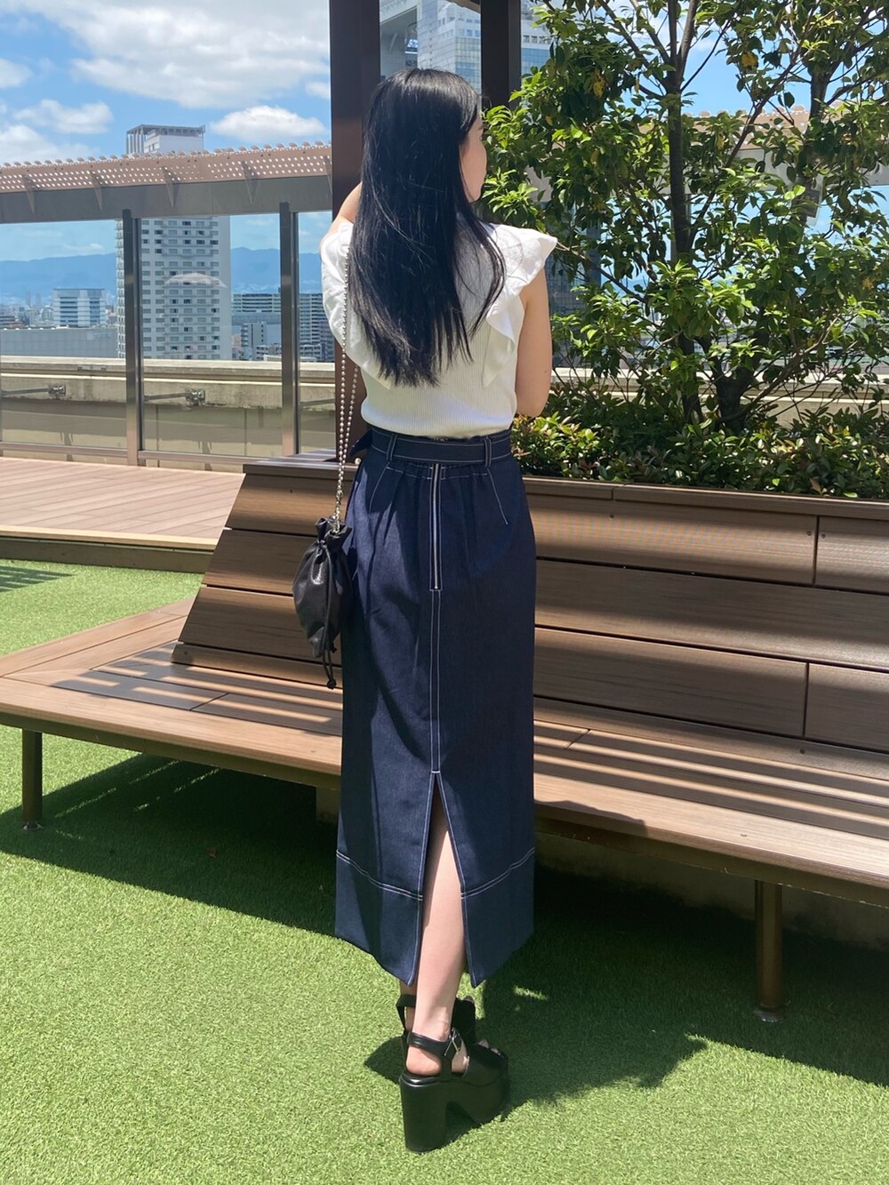 ホワイト系のニット/セーター、ブラック系のスカートを着用したレディースの夏コーディネートの2枚目の写真