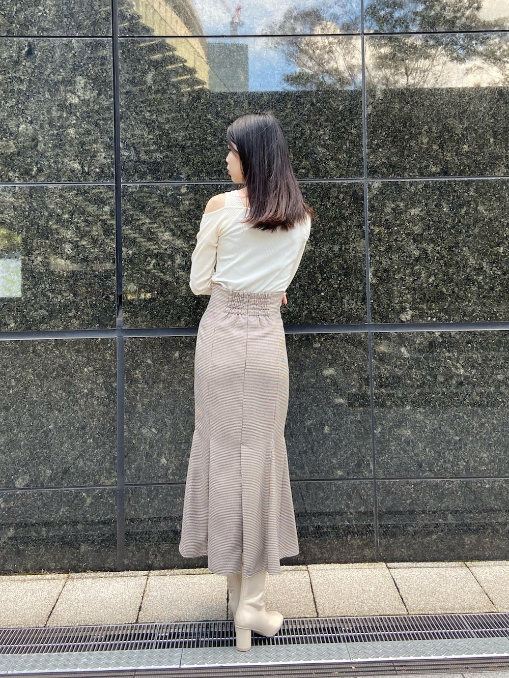 その他のスカート、ホワイト系のTシャツ/カットソー、ホワイト系のブーツを着用したレディースの秋コーディネートの3枚目の写真