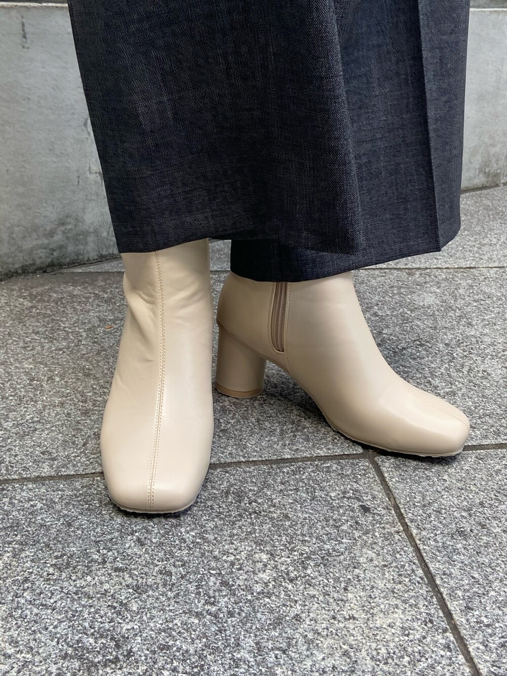 グレー系のテーラードジャケット、ブラック系のニット/セーター、グレー系のスラックスを着用したレディースの秋コーディネートの7枚目の写真