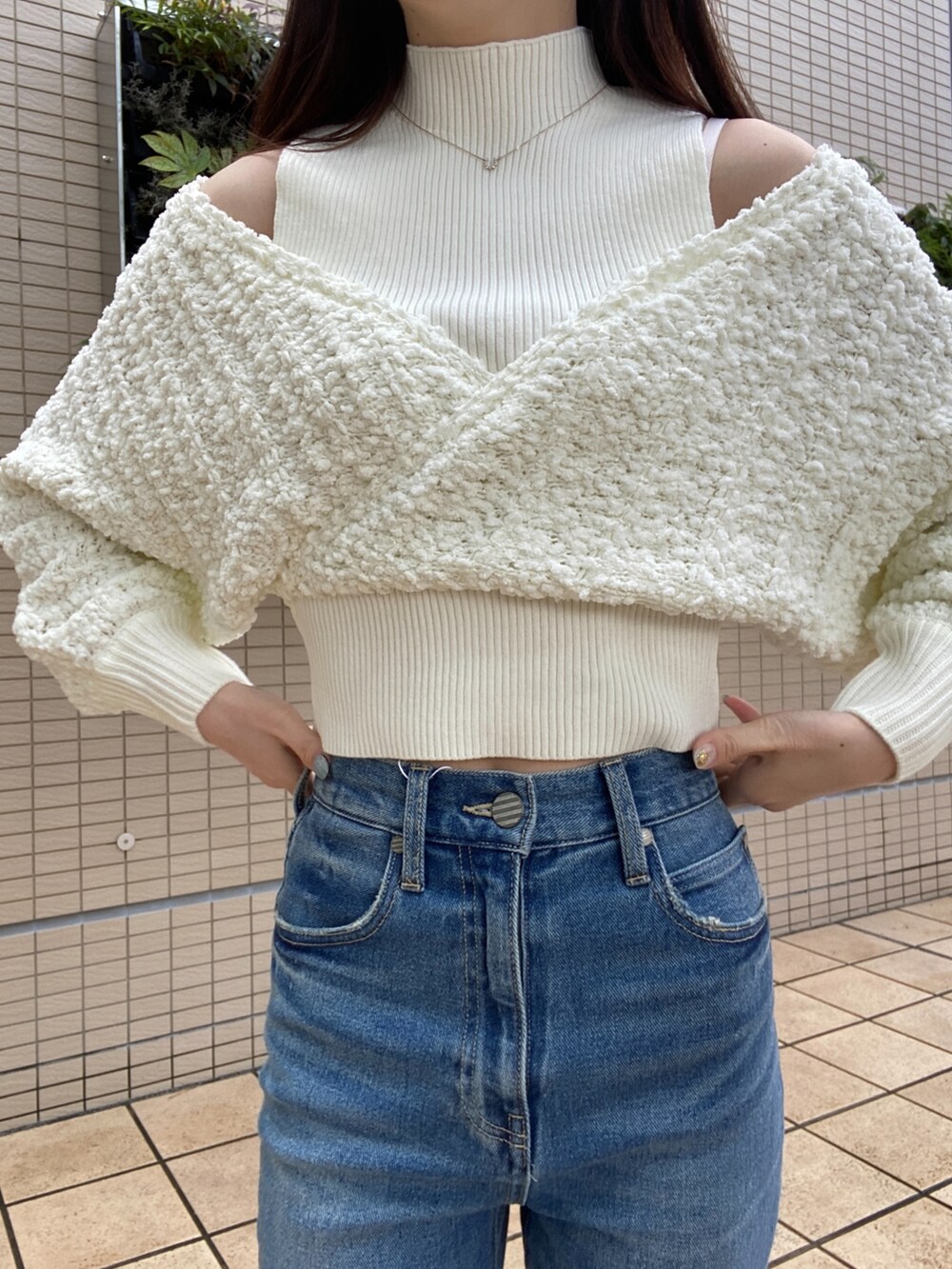 ブルー系のデニムパンツ、ホワイト系のニット/セーターを着用したレディースの秋コーディネートの5枚目の写真