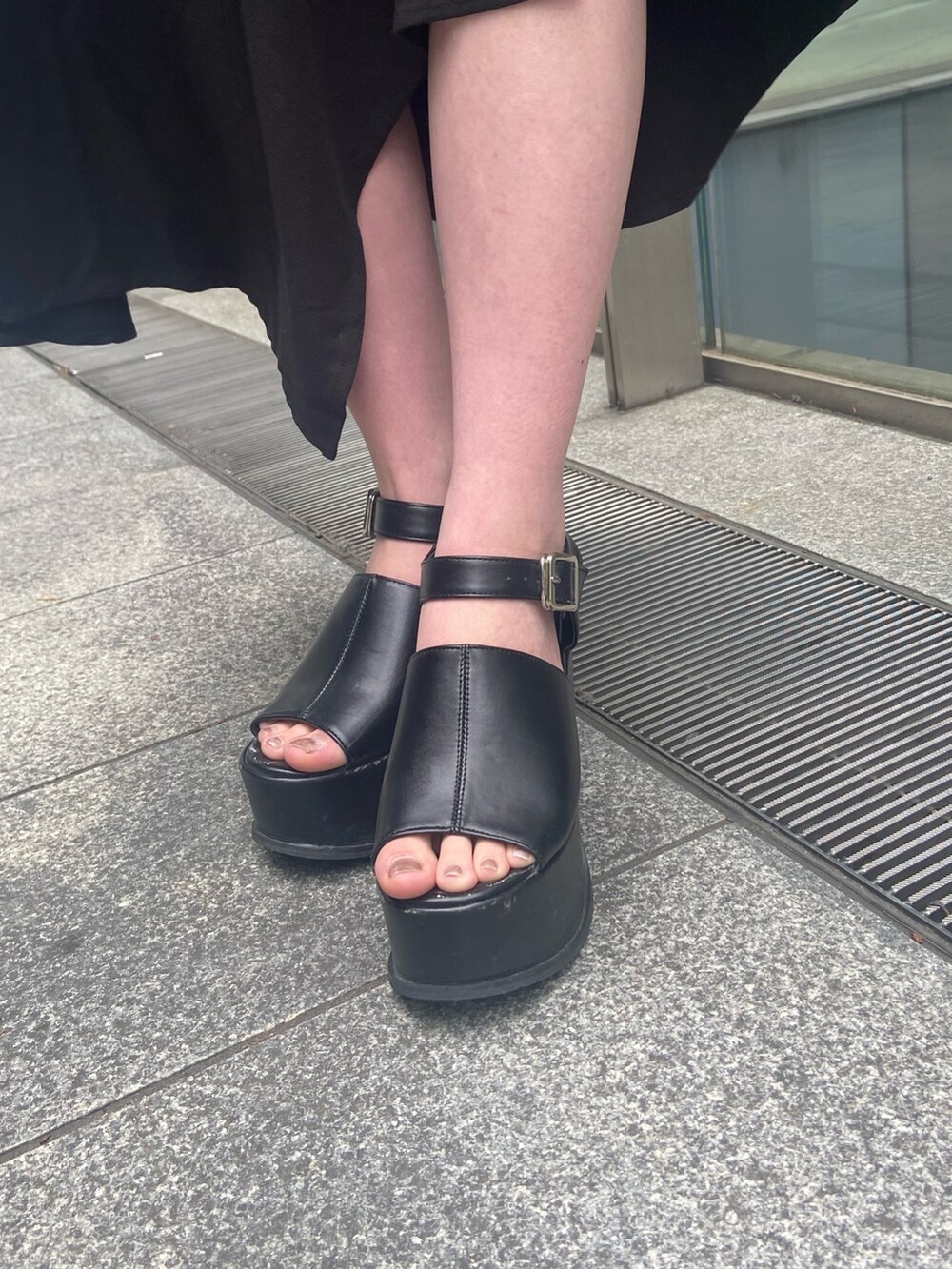 グレー系のニット/セーター、ブラック系のスカート、ブラック系のサンダルを着用したレディースの春コーディネートの6枚目の写真