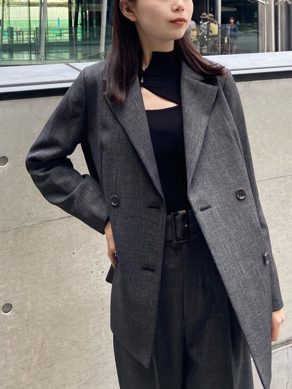 グレー系のテーラードジャケット、ブラック系のニット/セーター、グレー系のスラックスを着用したレディースの秋コーディネートの4枚目の写真