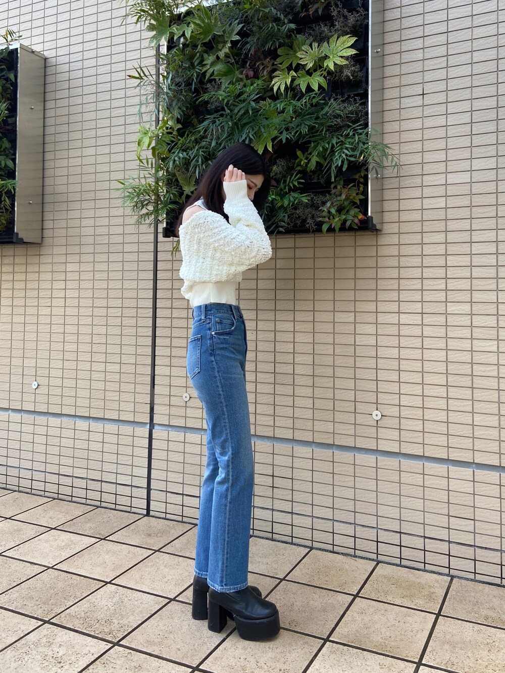 ブルー系のデニムパンツ、ホワイト系のニット/セーターを着用したレディースの秋コーディネートの3枚目の写真