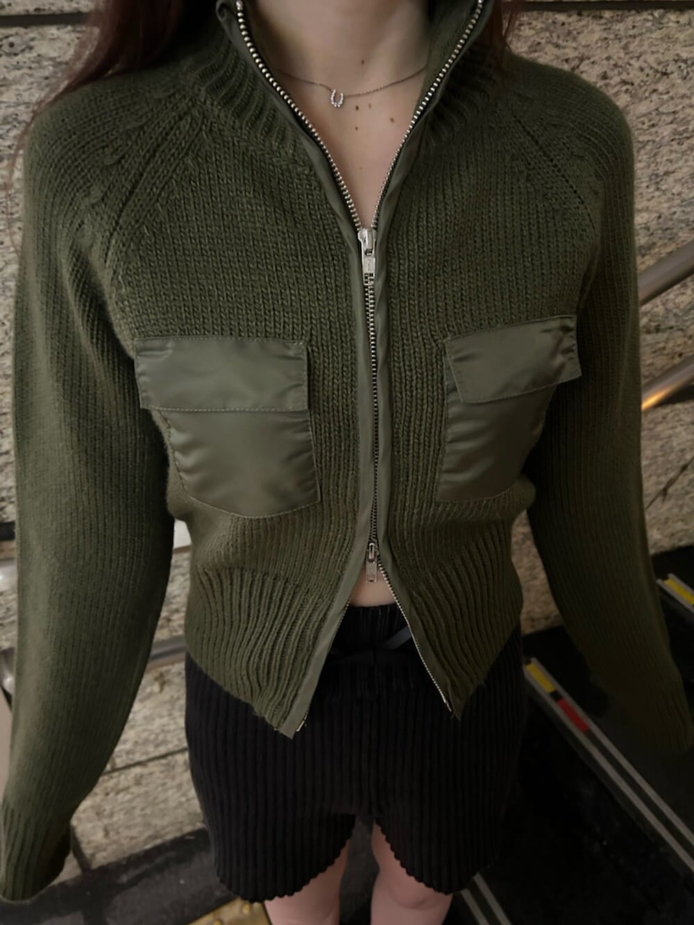 ブラック系のブーツ、グリーン系のニット/セーター、ブラック系のその他パンツを着用したレディースの冬コーディネートの5枚目の写真