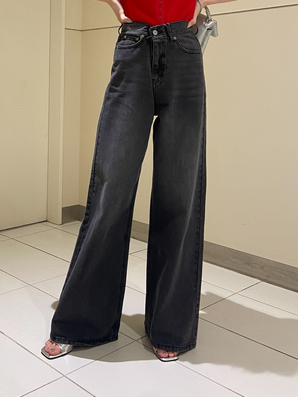 ブラック系のデニムパンツ、レッド系のニット/セーターを着用したレディースの夏コーディネートの5枚目の写真