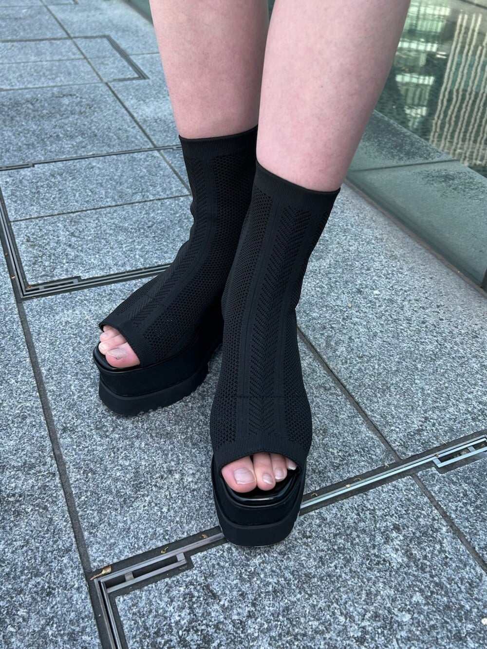 ブルー系のベスト、ブルー系のスカート、ホワイト系のタンクトップを着用したレディースの春コーディネートの6枚目の写真