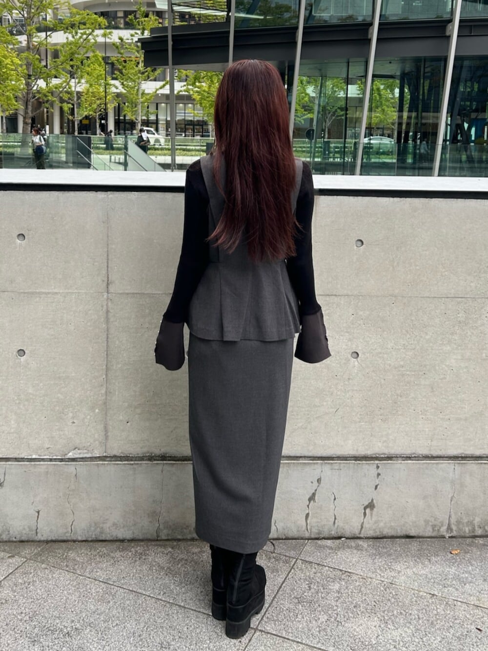 ブラック系のブーツ、グレー系のジャンパースカート、ブラック系のニット/セーターを着用したレディースの秋コーディネートの2枚目の写真