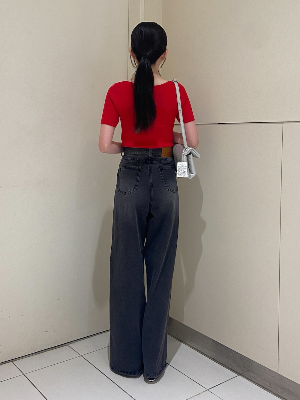 ブラック系のデニムパンツ、レッド系のニット/セーターを着用したレディースの夏コーディネートの2枚目の写真