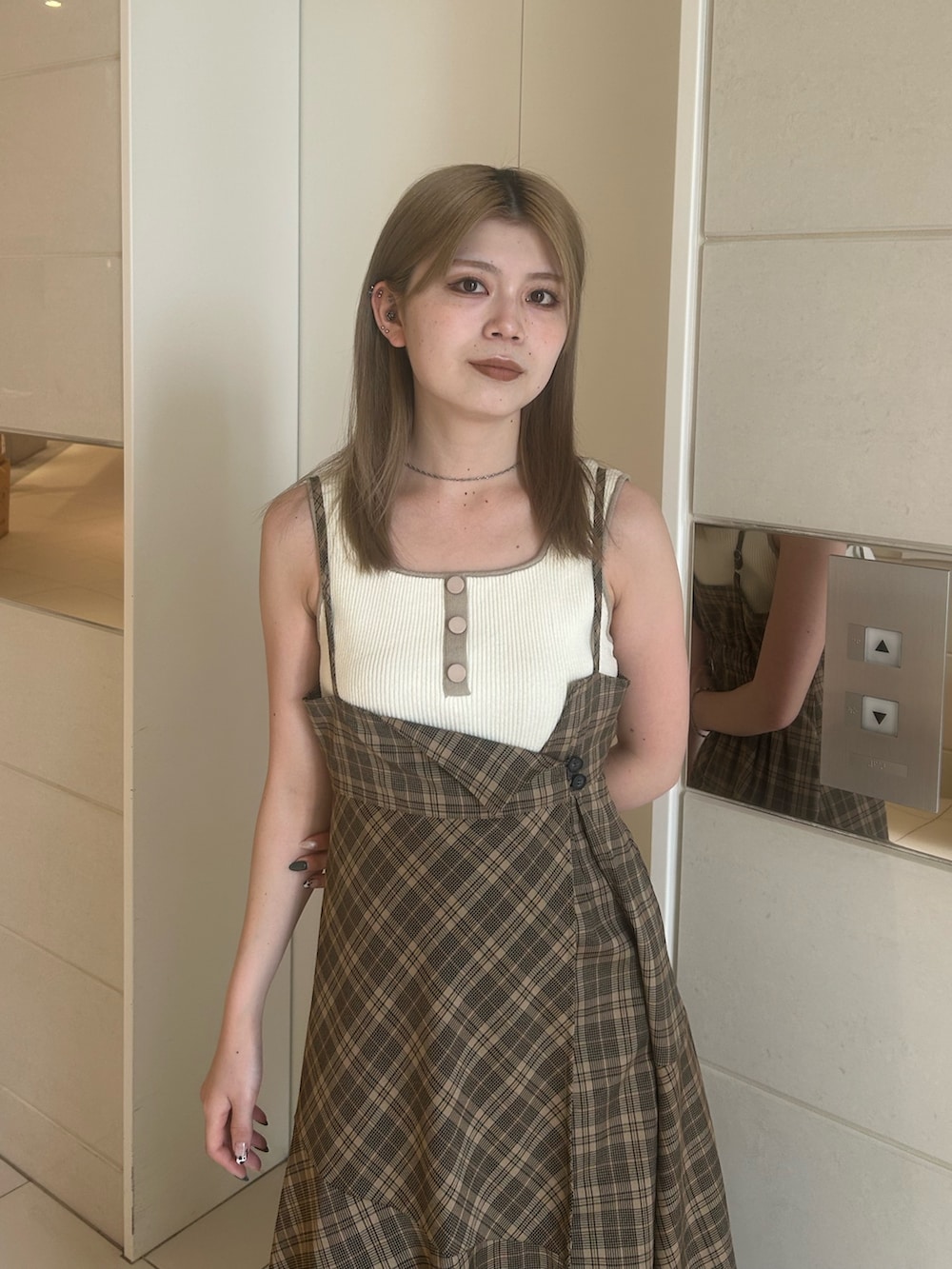 ベージュ系のワンピース、ホワイト系のニット/セーター、ブラウン系のブーツを着用したレディースの夏コーディネートの4枚目の写真