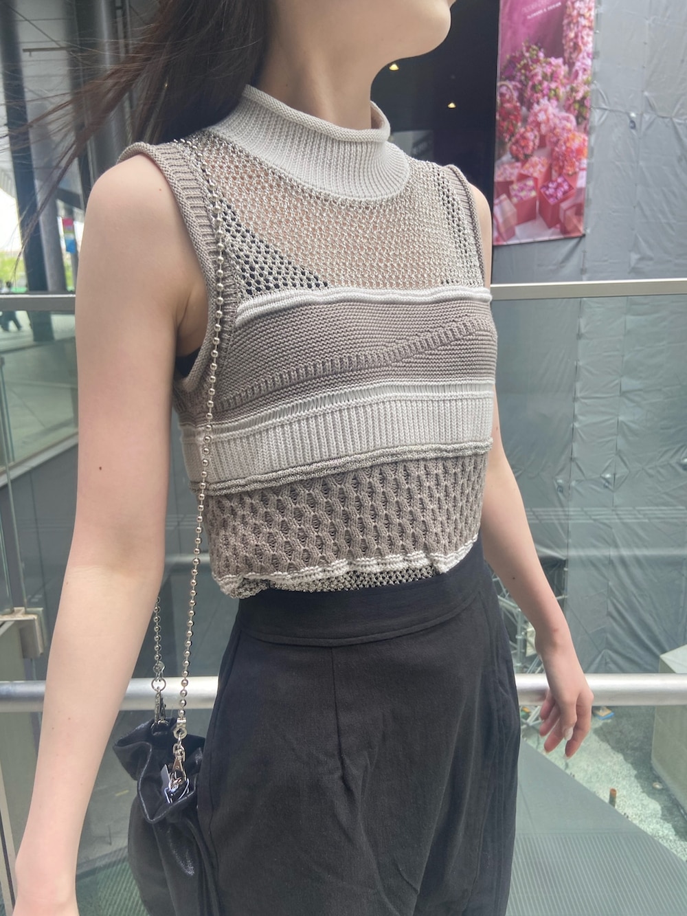 グレー系のニット/セーター、ブラック系のスカート、ブラック系のサンダルを着用したレディースの春コーディネートの4枚目の写真