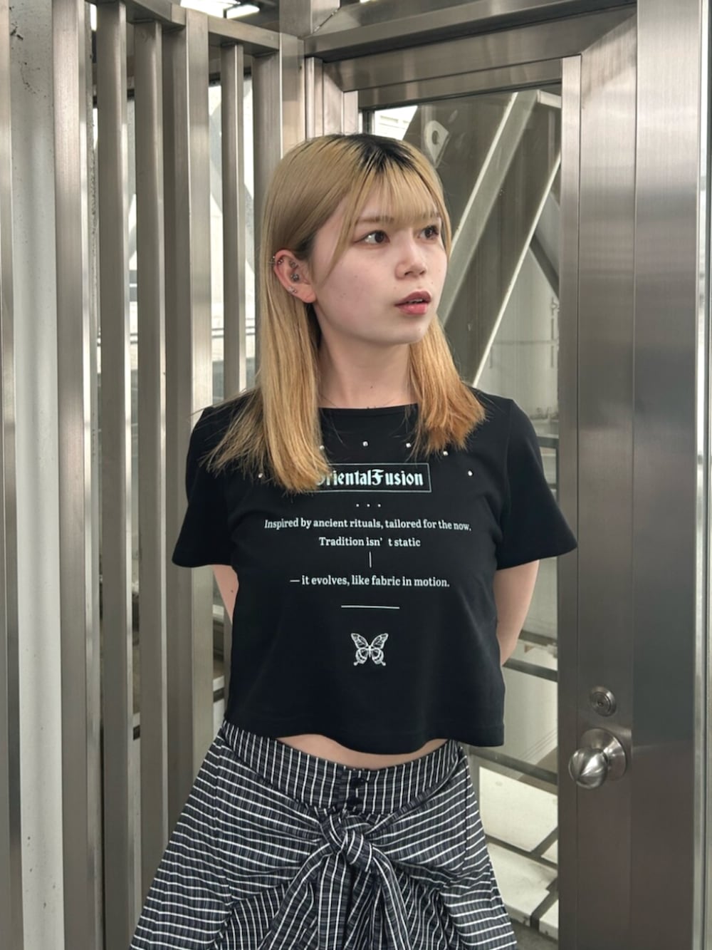 ブラック系のブーツ、ブルー系のスカート、ブラック系のTシャツ/カットソーを着用したレディースの夏コーディネートの4枚目の写真